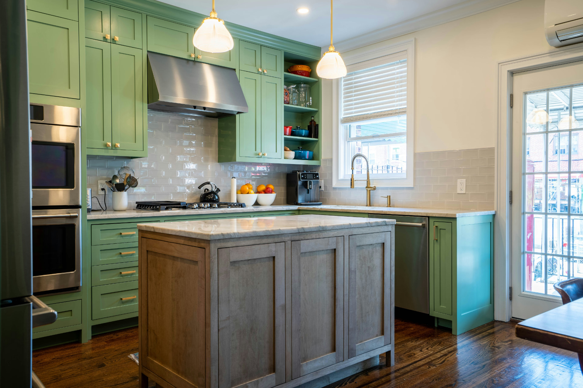 Refinished green shaker cabinetry and wood island in a bright custom kitchen