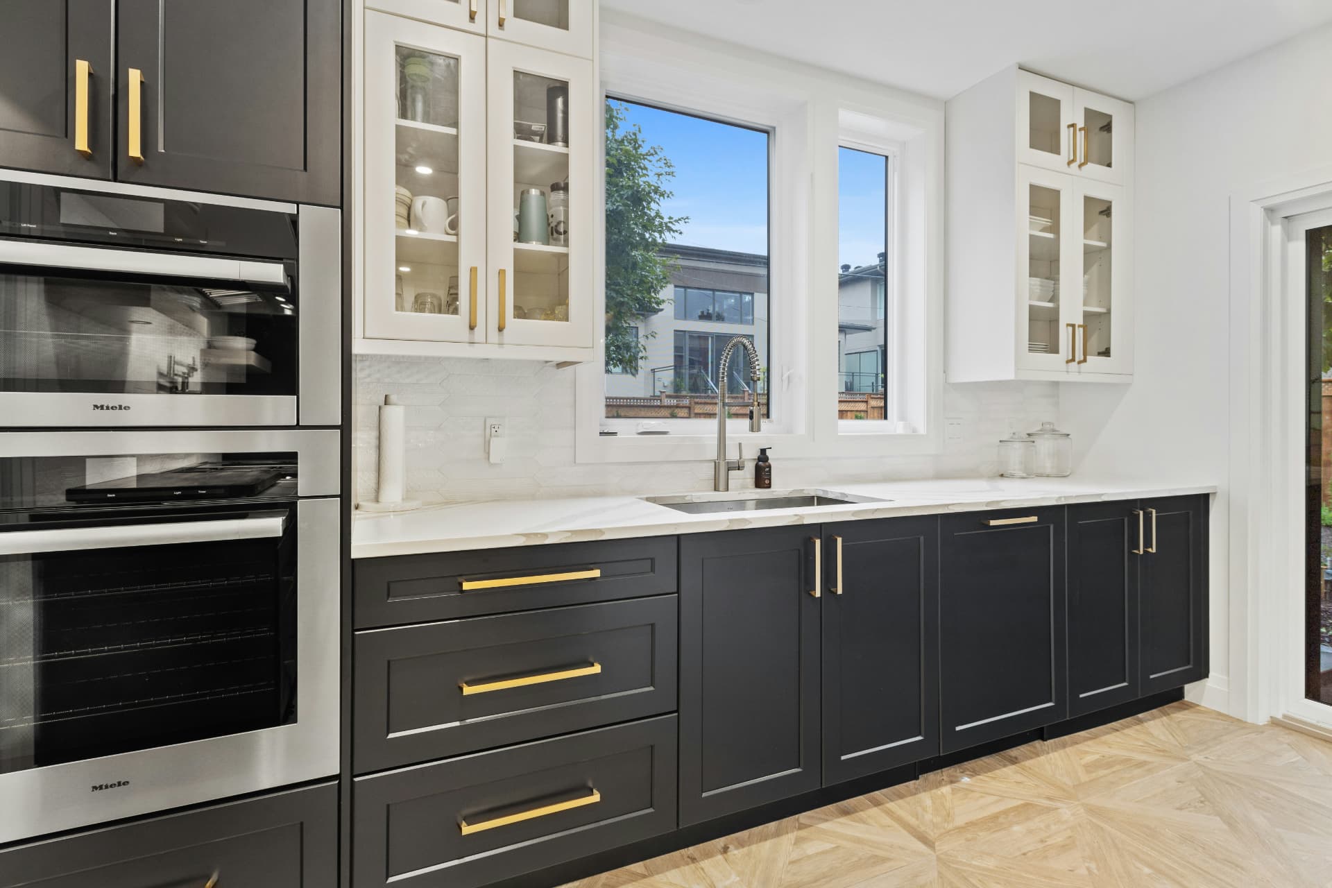 Remodeled kitchen with navy shaker cabinets, brass hardware, and white countertops