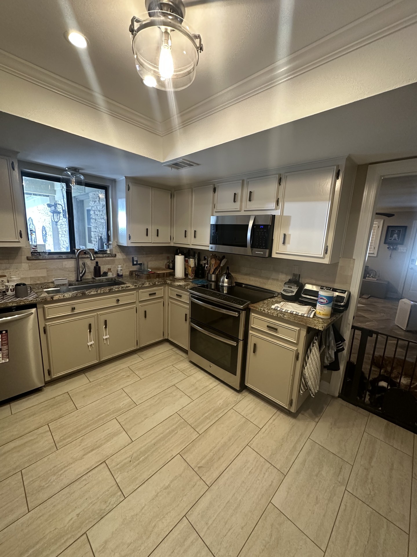 Worn cream-colored kitchen cabinets with dated hardware before refacing in Round Rock
