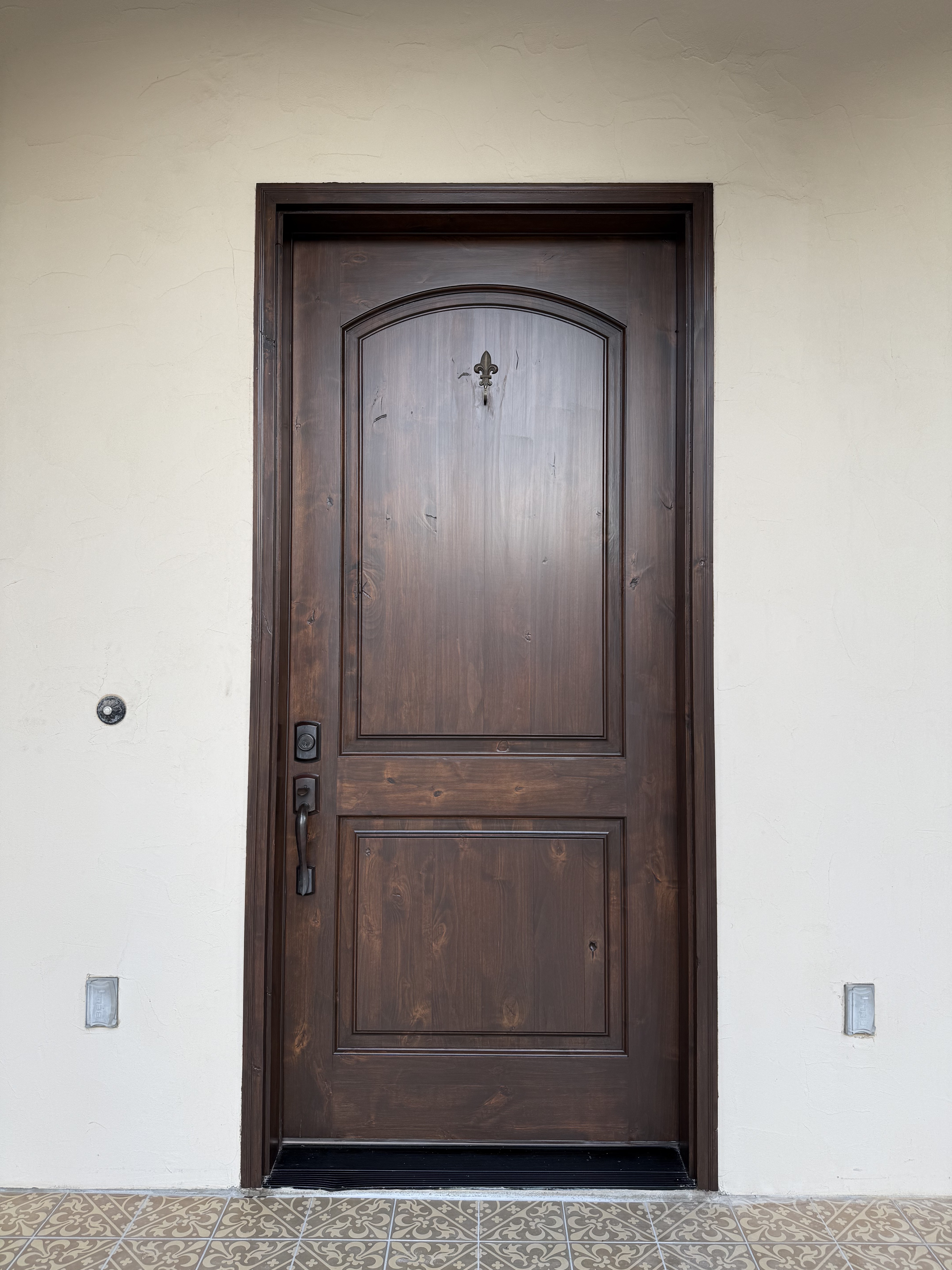 Refinished wood entry door with a rich, even dark-brown finish after restoration in New Braunfels